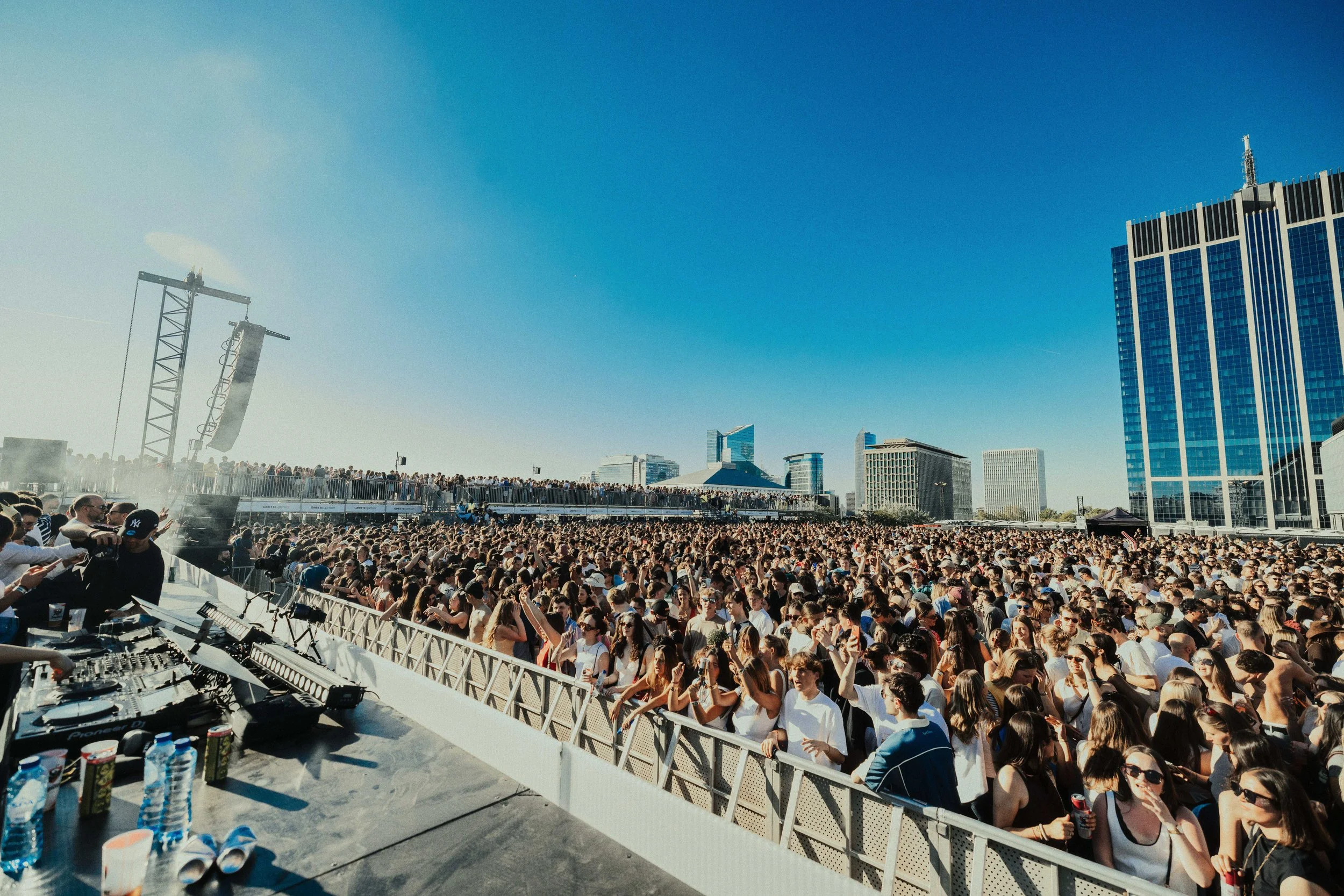 A festival crowd under a blue summer sky