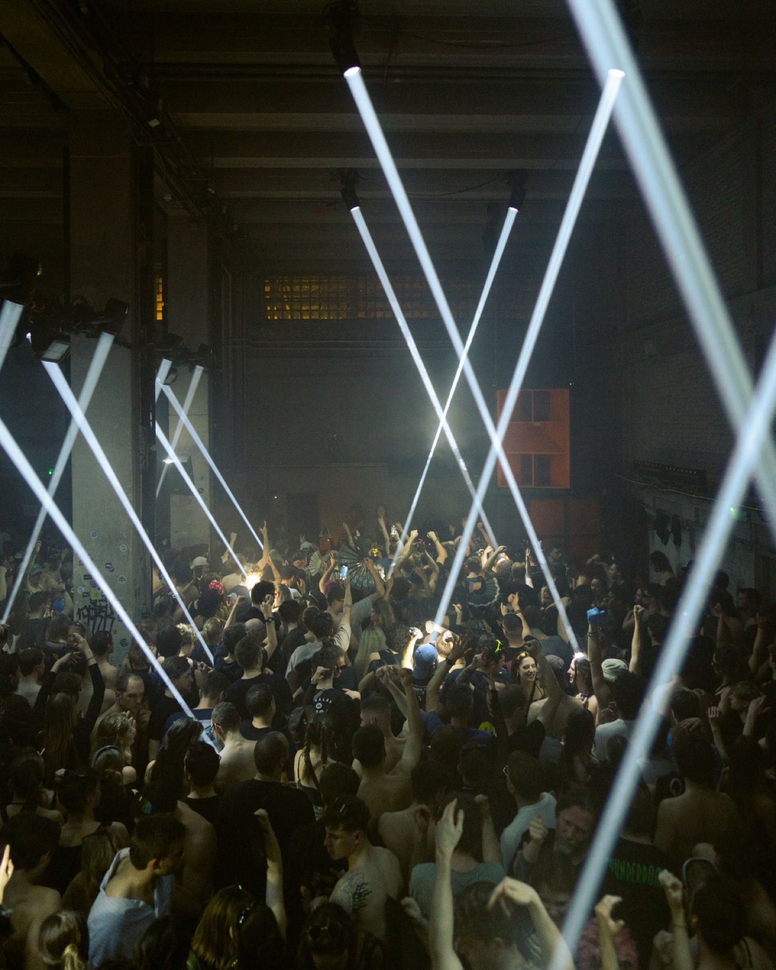 A packed venue under red lasers - the system running invisibly